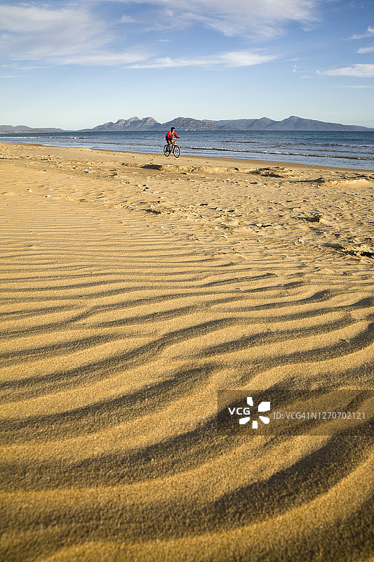 女人在澳大利亚塔斯马尼亚东海岸的九英里海滩上享受自行车之旅。图片素材