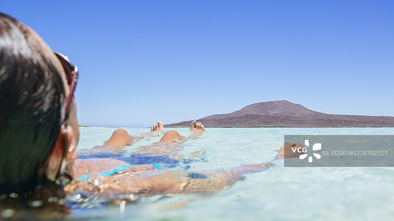 女人漂浮在墨西哥下加利福尼亚州科罗纳多岛的海中图片素材