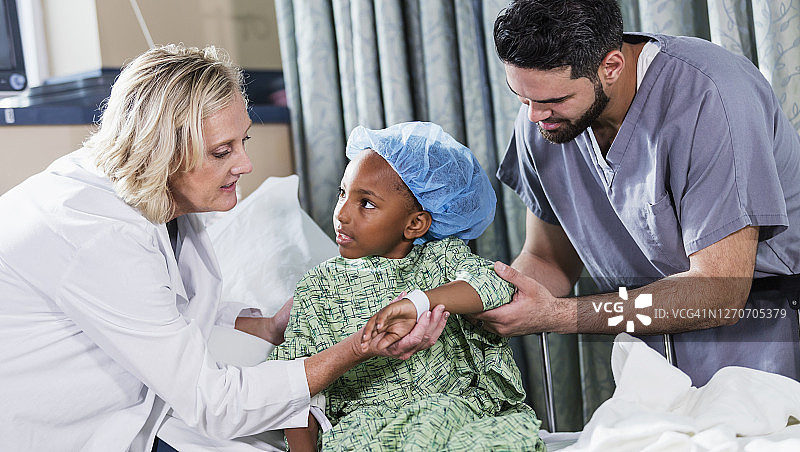 医生和护士帮助坐在病床上的女孩图片素材