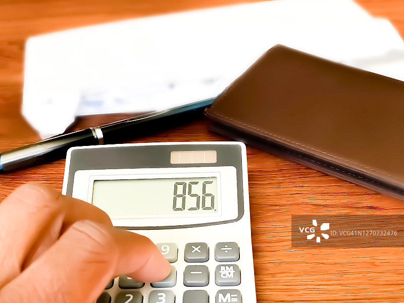 非裔美国妇女使用计算器支付账单，显示余额为正图片素材