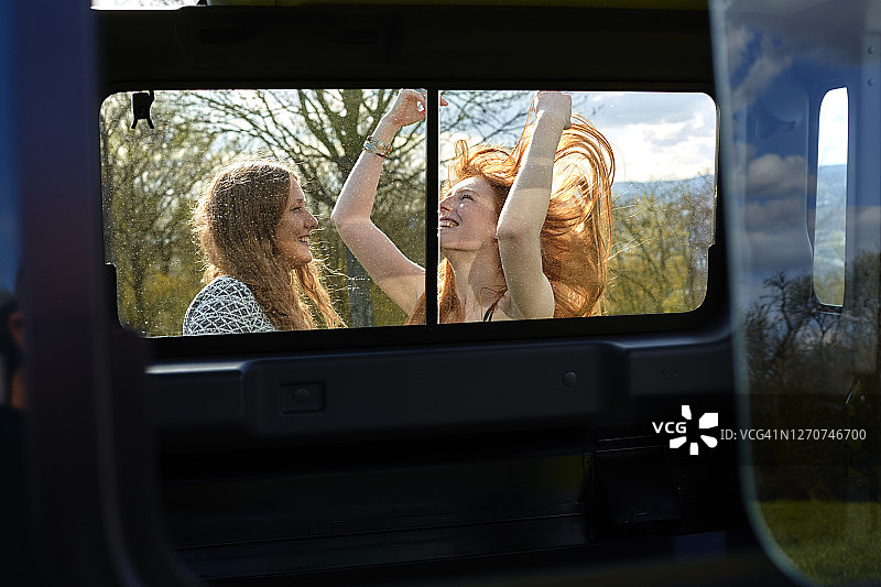 车后方的两个快乐的年轻女子图片素材