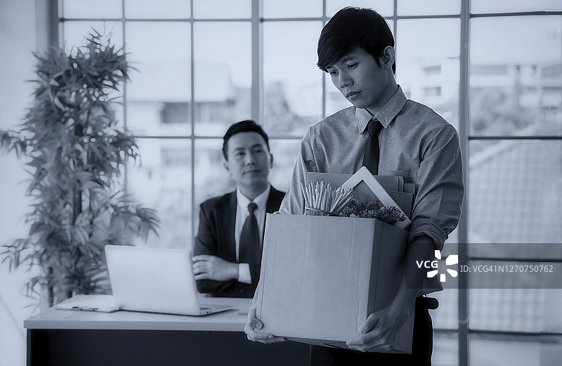 老板与员工在办公室争吵，员工抱着纸箱离开图片素材
