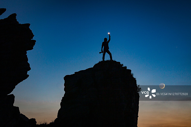 徒步旅行者站在山顶观看月落图片素材