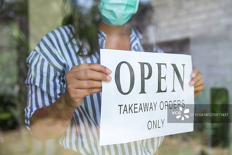 当地餐馆店主挂出外卖开放标志（不可辨认）图片素材
