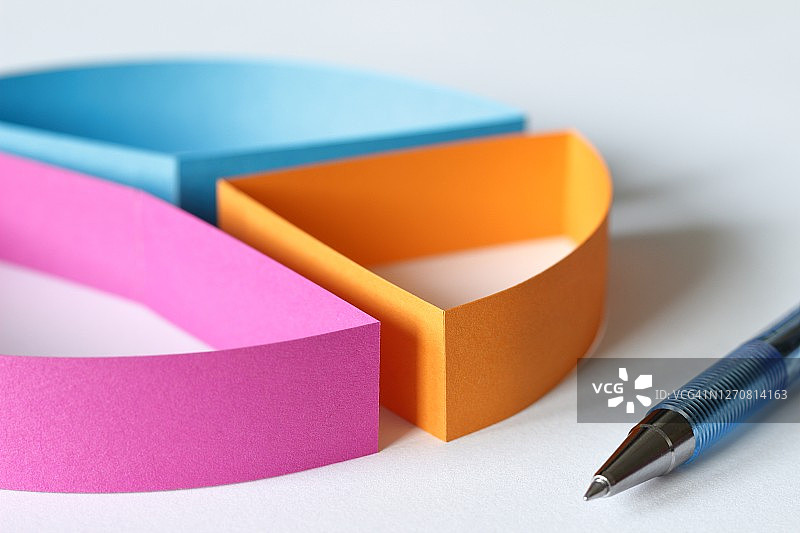 带笔的彩色纸质饼图特写图片素材