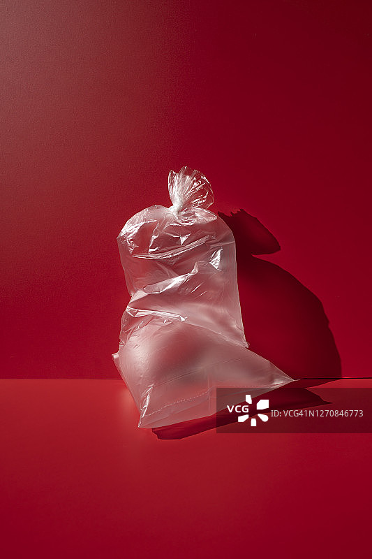 红色背景上的透明塑料袋图片素材