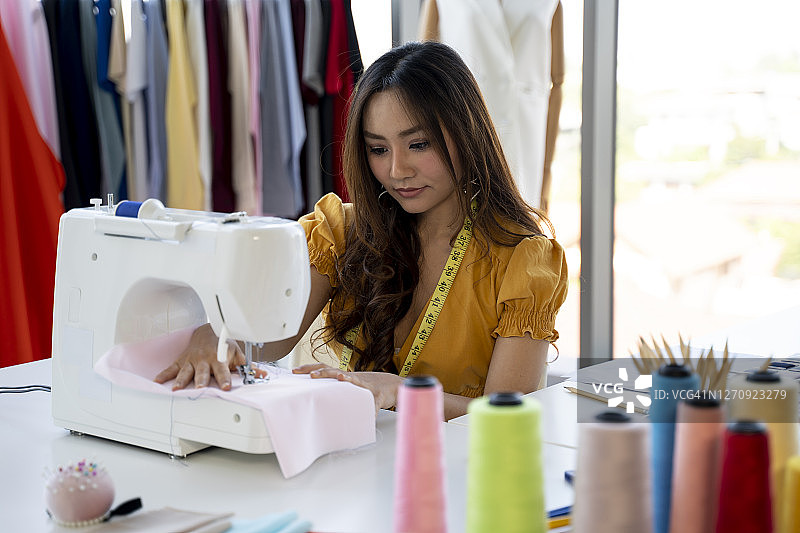 年轻女设计师在工作室使用机器图片素材