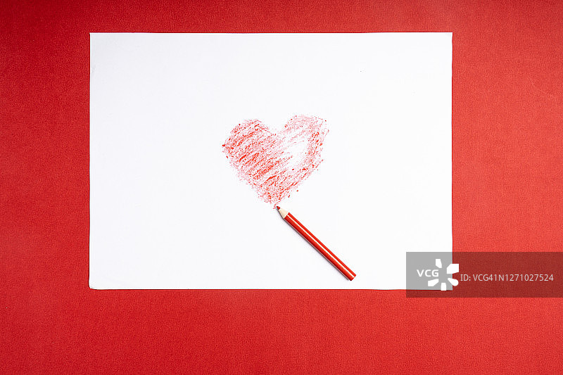 红色背景上的心形和铅笔特写图片素材