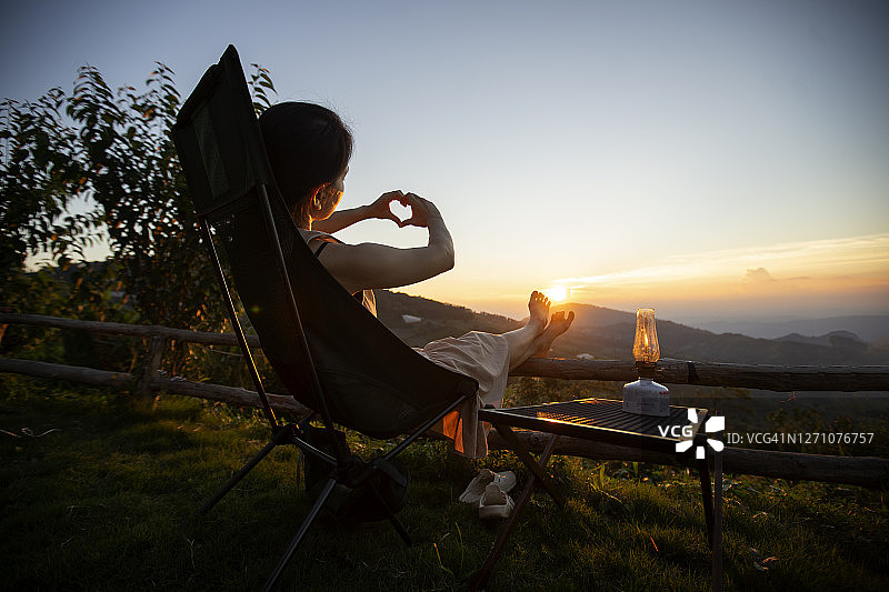 对气候和日落感到快乐的年轻露营女性图片素材