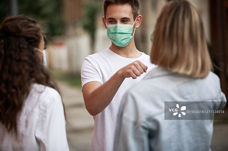 年轻人与女性朋友见面时互相碰拳图片素材