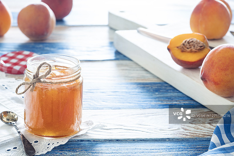 装在玻璃罐中的自制桃子酱与砧板上的桃子图片素材