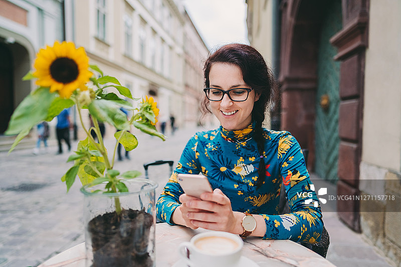 在路边咖啡馆使用智能手机的游客图片素材