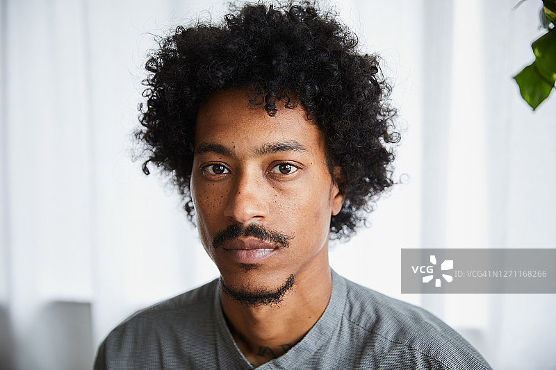 独自坐在家里的自信年轻人图片素材