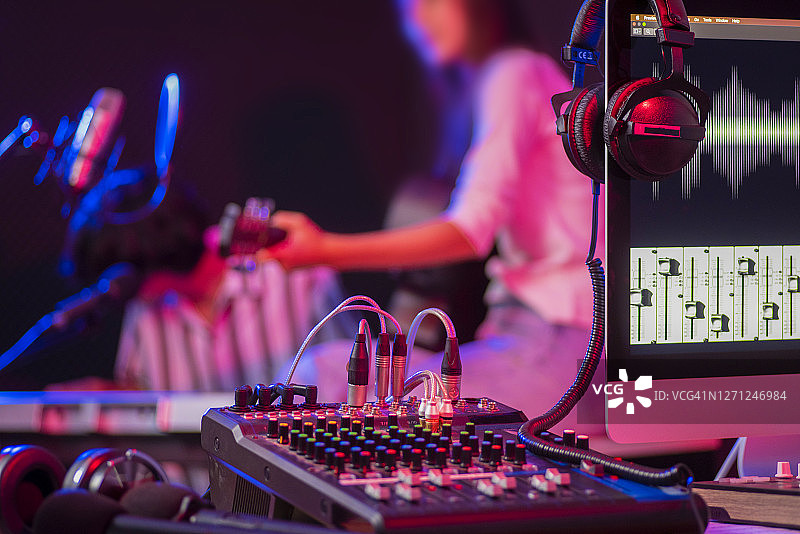 家庭录音室中乐器、耳机与调音台特写图片素材