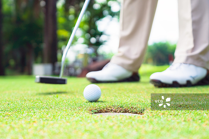 高尔夫球手在球场上准备推杆图片素材