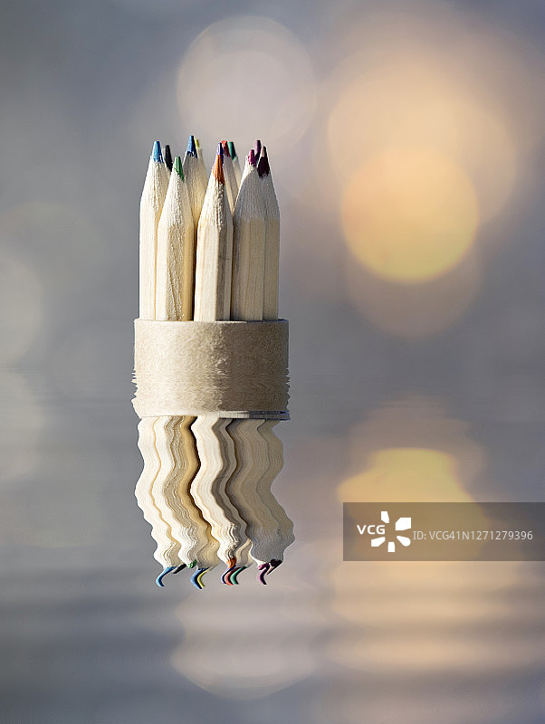 水中倒影的一排彩色木质铅笔图片素材