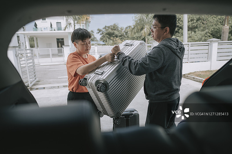 准备将行李装入SUV去度假的中国夫妇图片素材