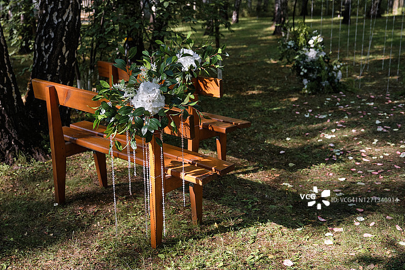 用鲜花装饰的棕色木制长椅婚礼装饰图片素材