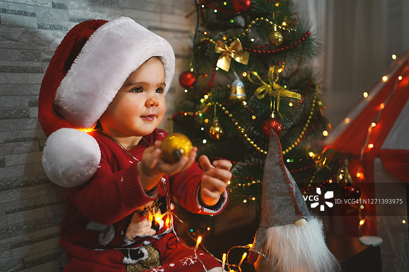 戴着圣诞帽的女童在圣诞装饰中图片素材