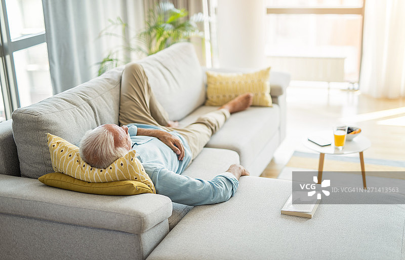 在客厅里睡觉的年长男人图片素材