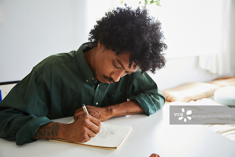 专注的年轻艺术家在速写本上画画图片素材