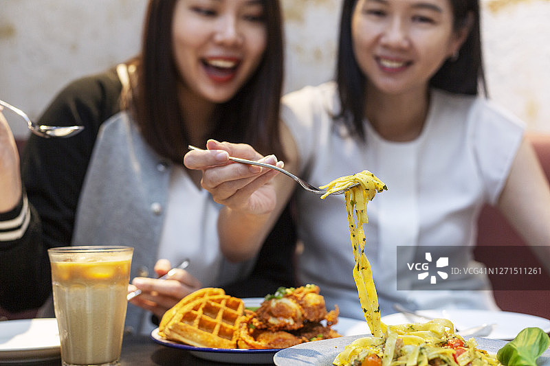 朋友在咖啡馆分享意大利面特写图片素材