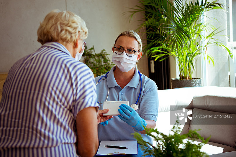 护士在家庭访问期间与老年妇女交谈图片素材