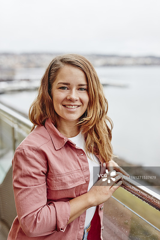 在阳台上看着镜头的女人图片素材