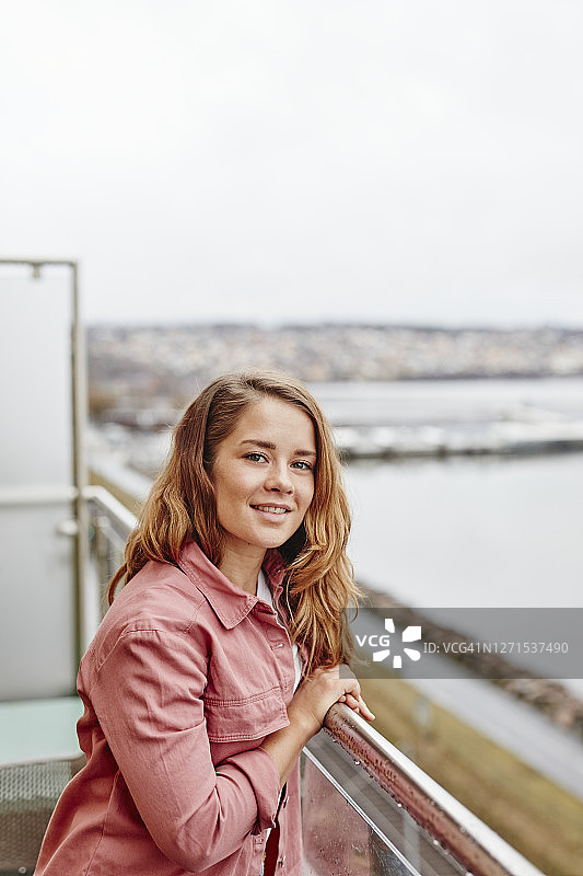 在阳台上看着镜头的女人图片素材