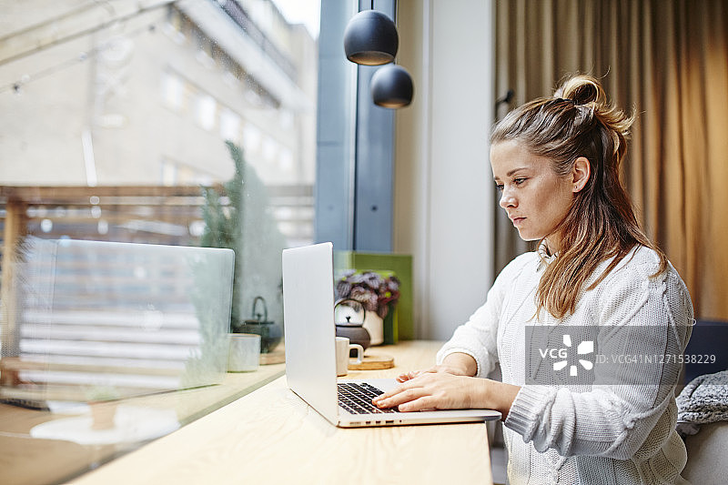 在咖啡馆使用笔记本电脑的女人图片素材