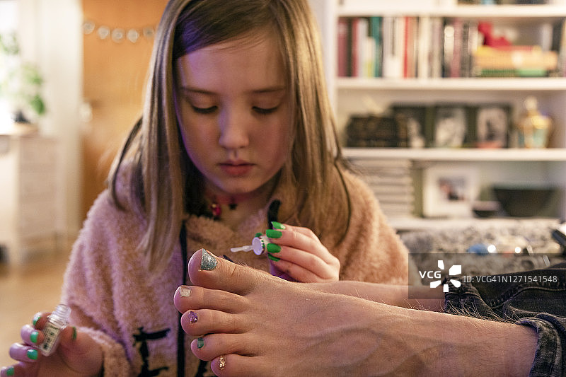 女孩给父亲涂指甲油图片素材