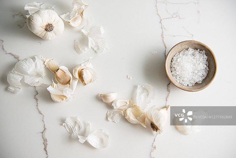 大蒜瓣和盐在白色大理石台面上图片素材