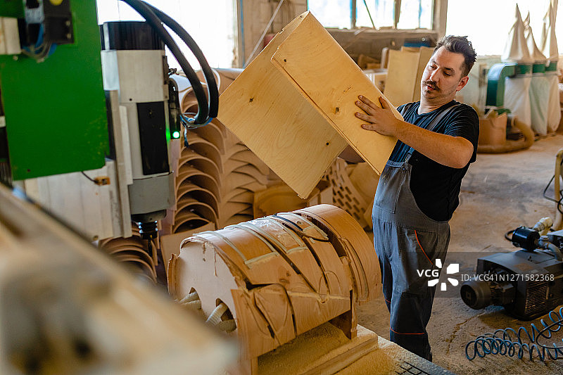 维修工人在家具厂使用数控机床工作图片素材