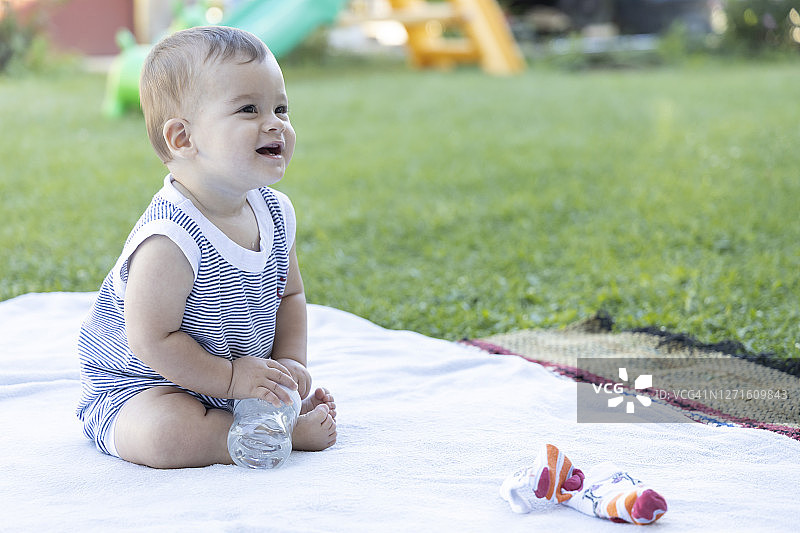 可爱的宝宝坐在家里花园里笑着图片素材