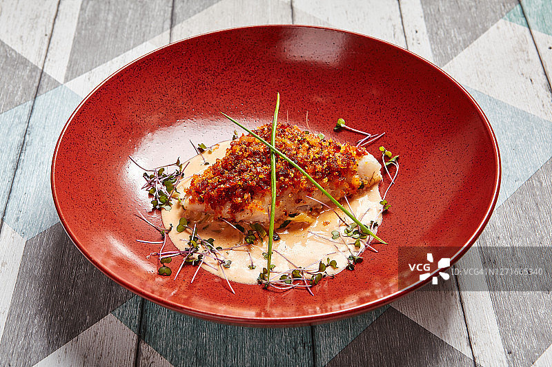 红盘中的鳕鱼块佐酱汁图片素材