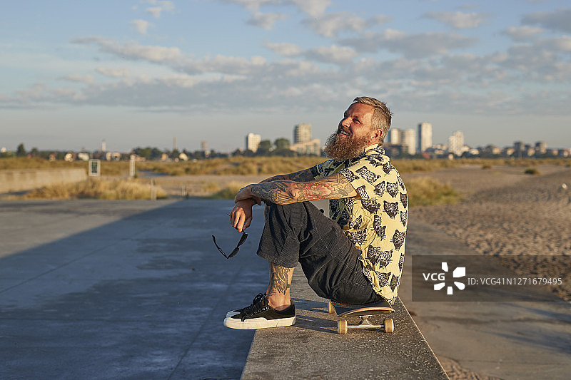 戴着太阳镜在日落时分远眺的时尚人士图片素材