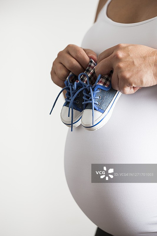 孕妇拿着婴儿鞋图片素材