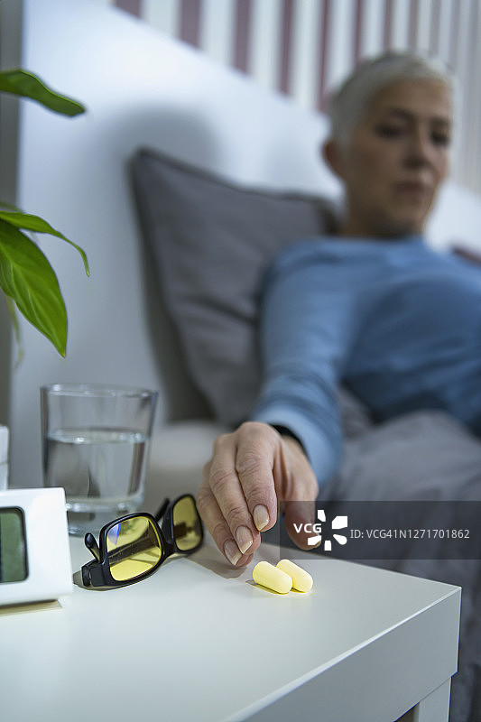 中年妇女睡前戴耳塞图片素材
