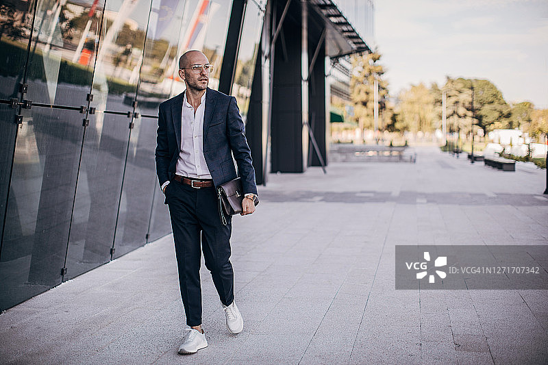 在城市中心漫步的年轻英俊商人图片素材