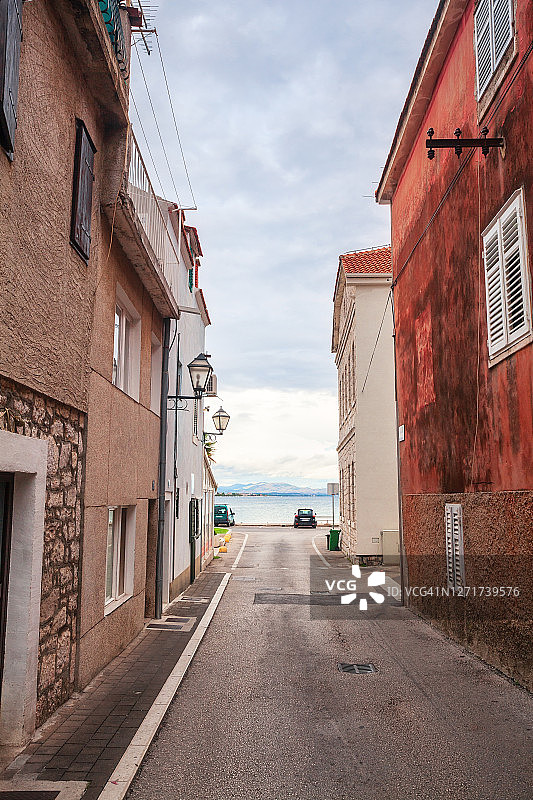 通往大海的城镇道路，房屋间的狭窄街道图片素材