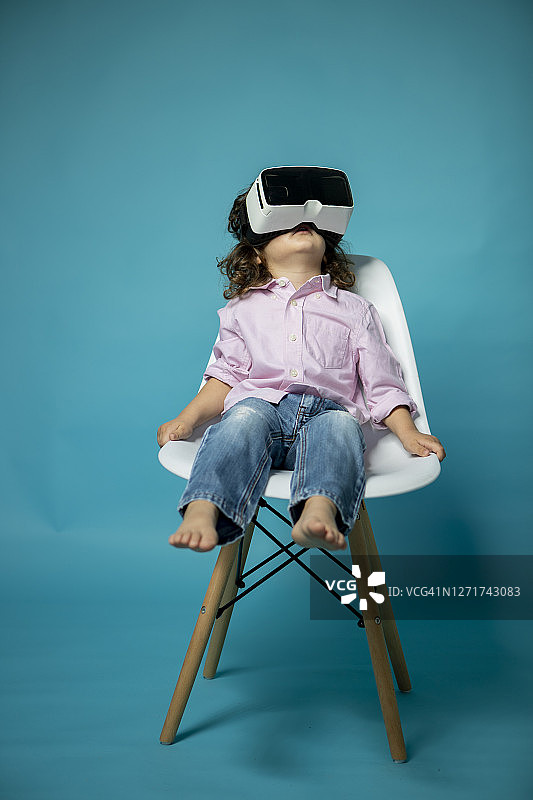 戴着虚拟眼镜的三岁男孩摄影棚照图片素材