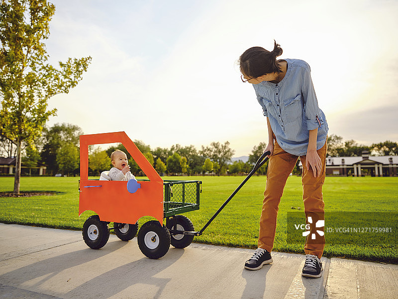 坐在自制橙色汽车里的女婴图片素材