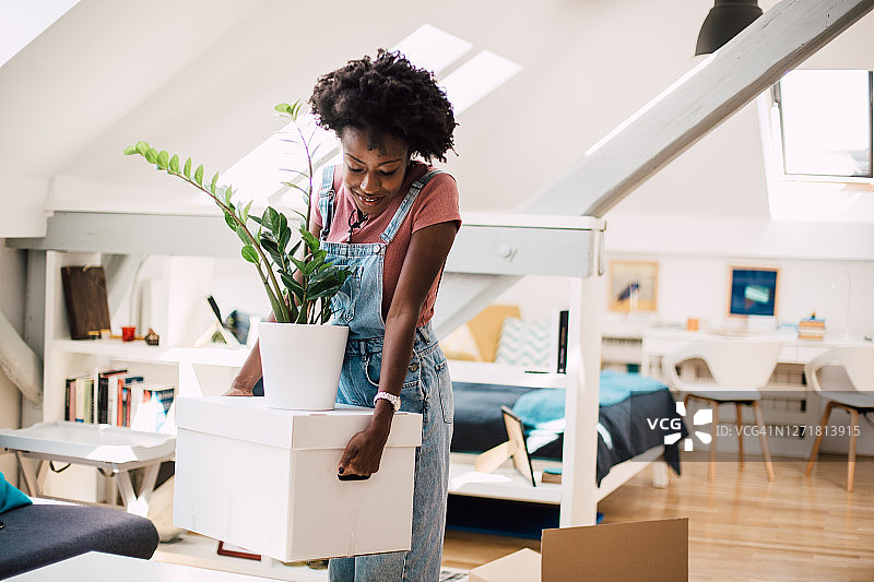 年轻的非裔美国妇女搬家时携带打包好的物品图片素材