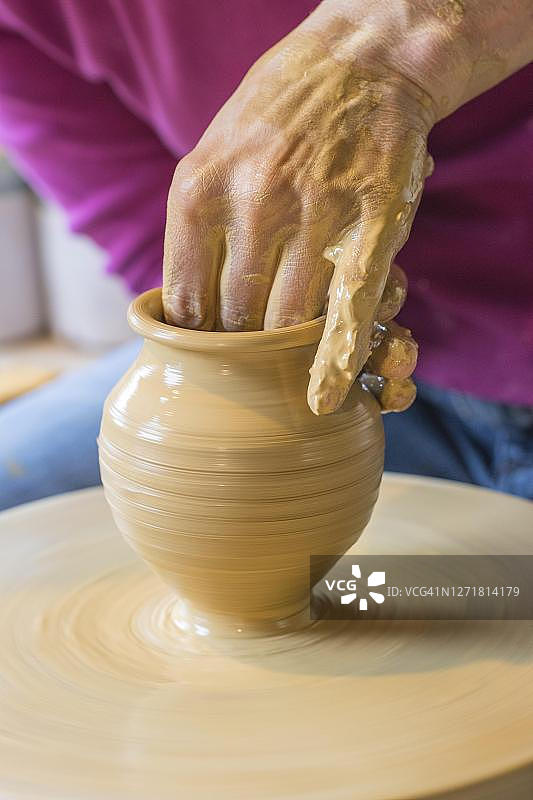 德国下萨克森州克洛彭堡：陶艺家在陶盘上手工制作花瓶图片素材