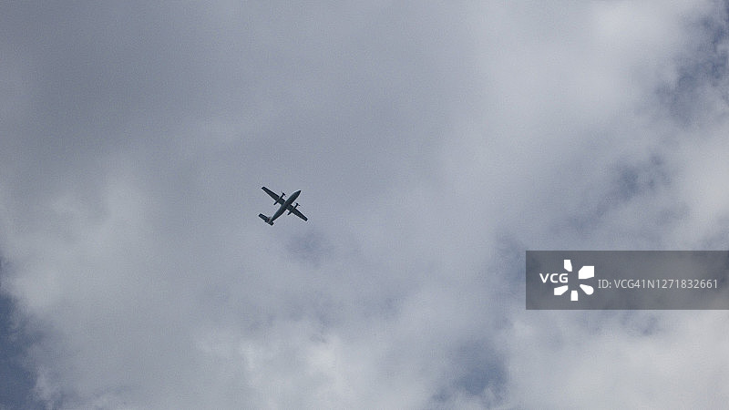 仰望飞行中的双螺旋桨飞机图片素材