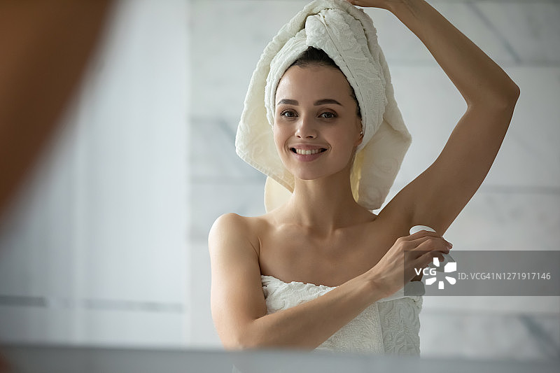 淋浴后使用除臭剂的微笑女性特写图片素材