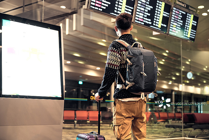 在机场航站楼查看到港离港信息板的游客图片素材