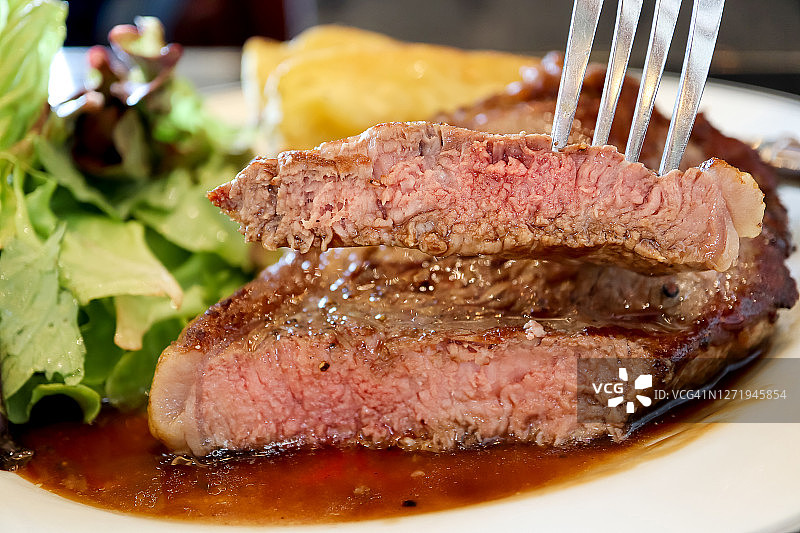 西冷牛排特写，搭配棕色酱汁，美食概念图片素材
