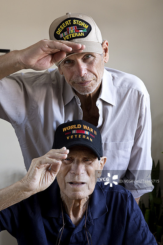 二战老兵与海湾战争退伍军人儿子在家中敬礼看向镜头图片素材