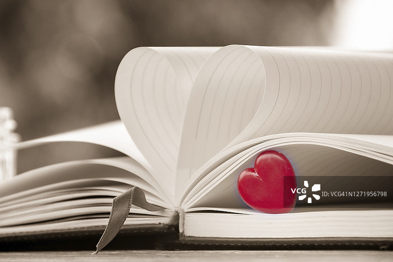 浪漫与爱人概念：红色心形模型和书的复古风格特写图片素材